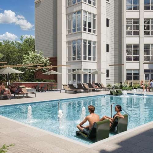 a group of people sitting in a pool in a large courtyard
